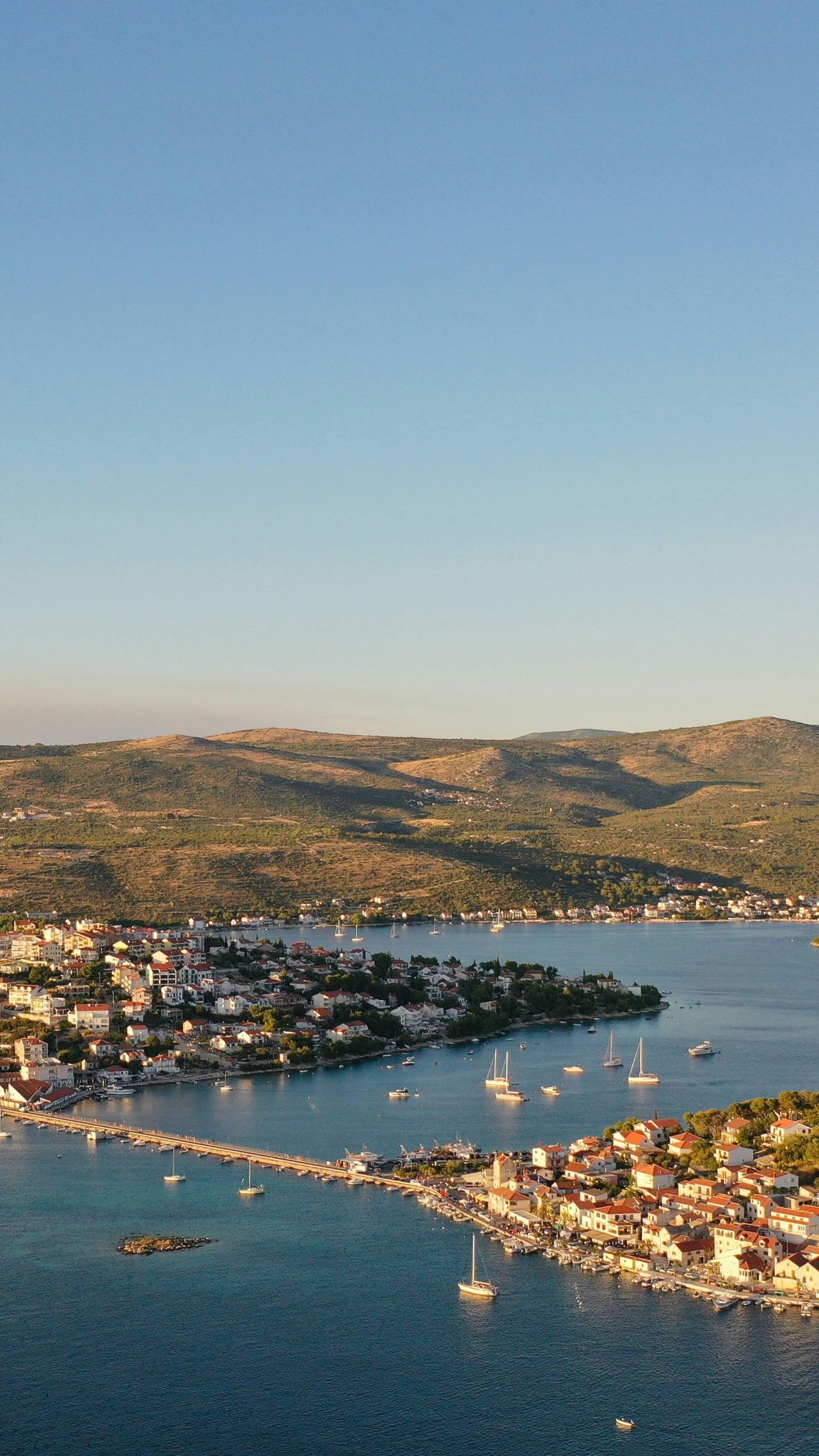 Aerial view of Rogoznica, with the causeway to the old town and yachts at anchor in the bay